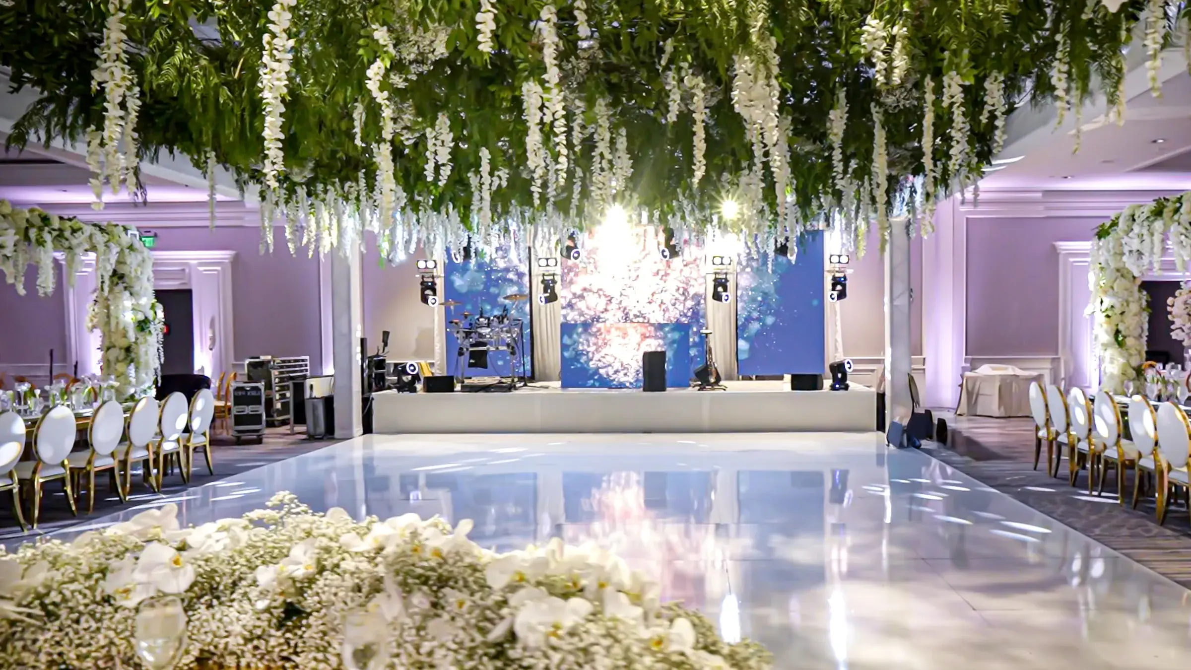Ballroom set for a celebration with LED video walls, stage lighting and a white dance floor at The Ritz-Carlton, Marina del Rey