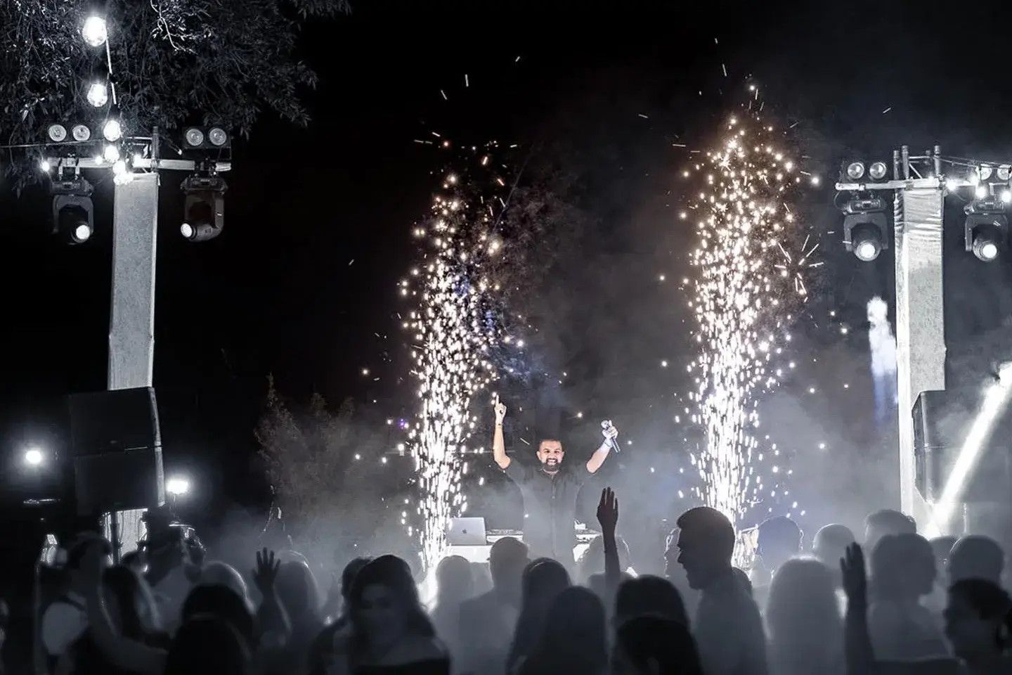 Stage lighting, moving heads on truss and cold-spark effects at a night event produced by DJ Next Level