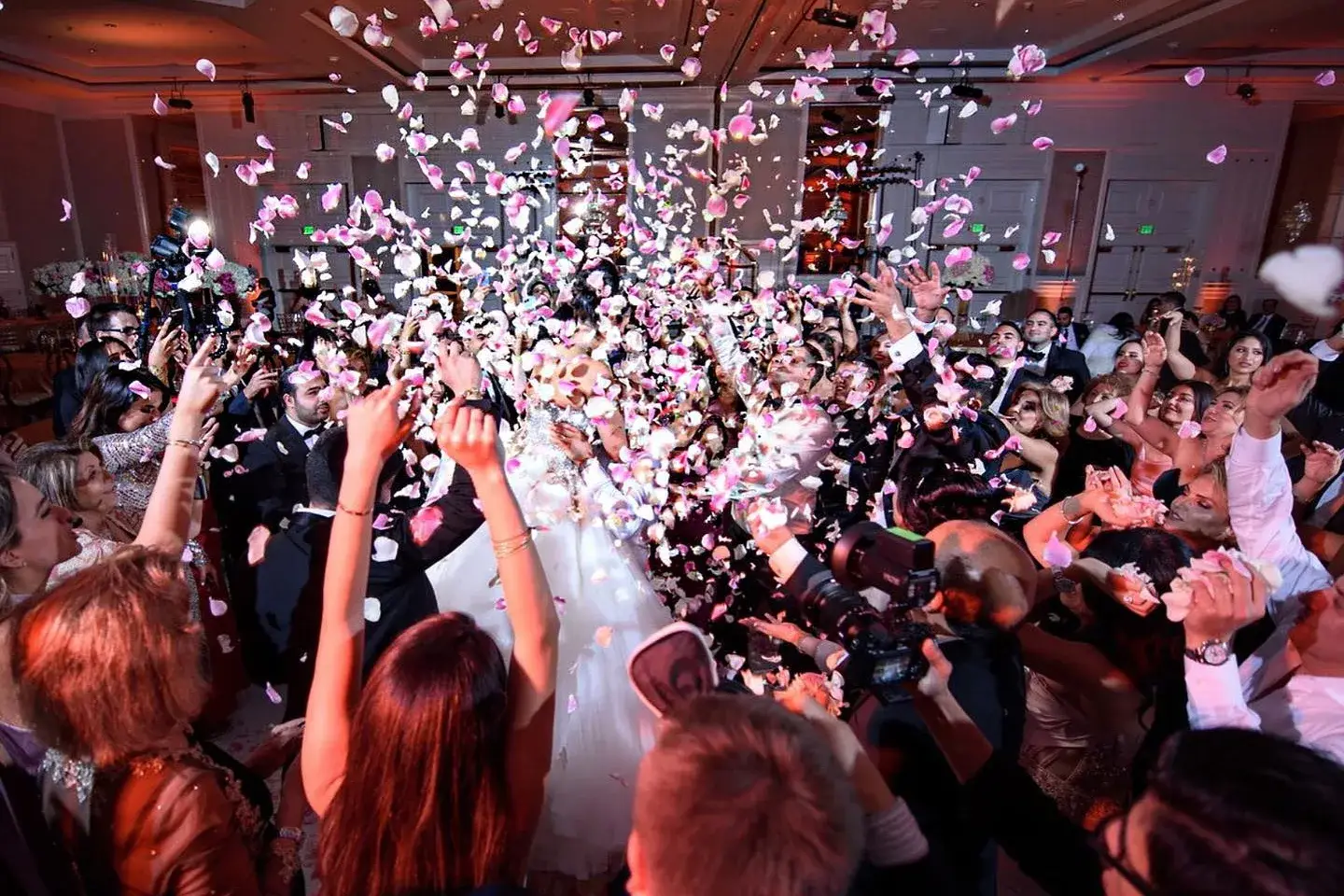 Confetti cannon burst over guests celebrating on a crowded dance floor