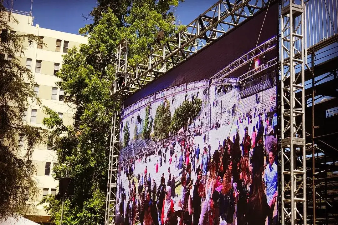 Large outdoor LED video wall mounted on truss for a live audience