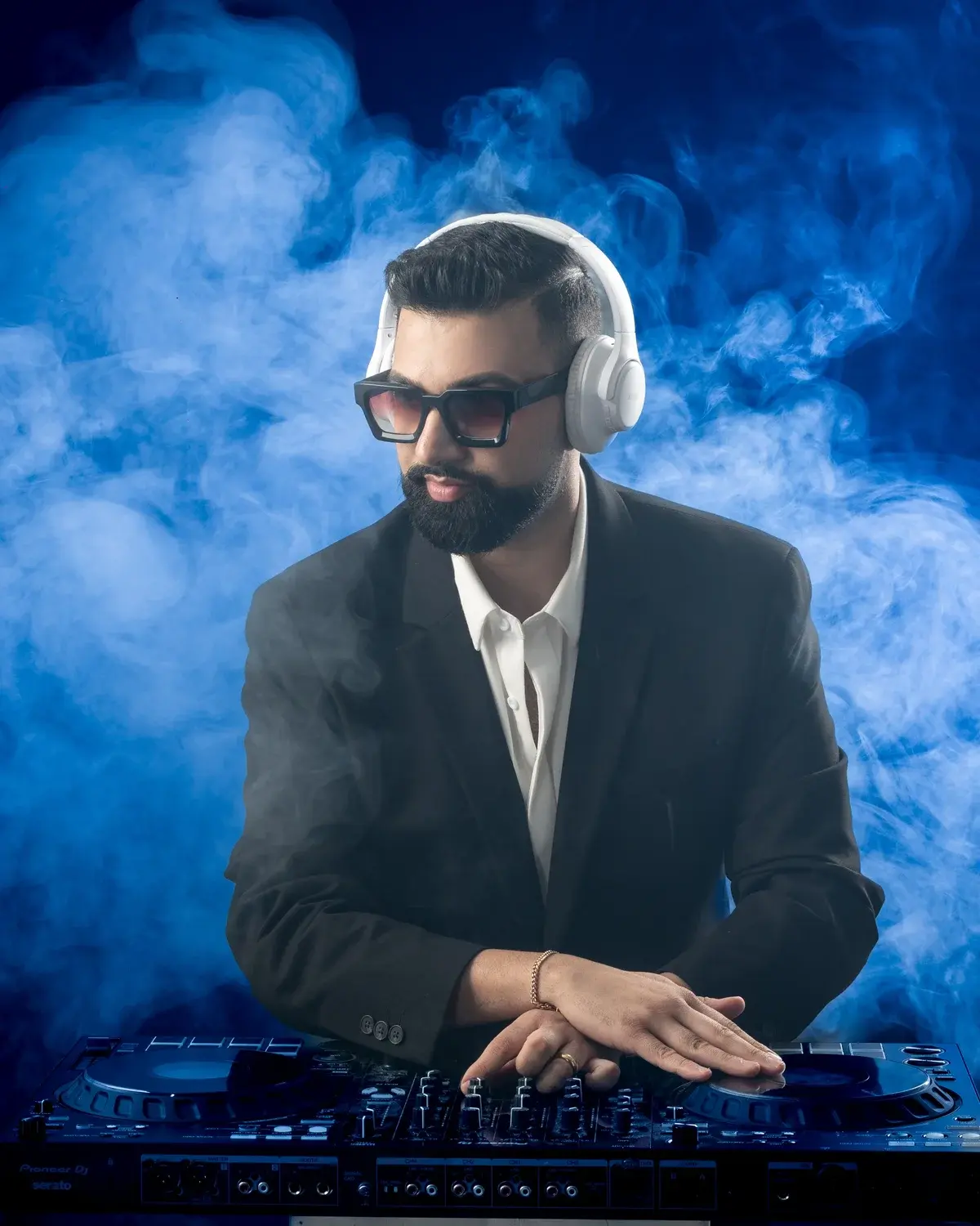 Aryan Rabizadeh, founder and lead DJ of DJ Next Level Entertainment, at the DJ controller in blue haze