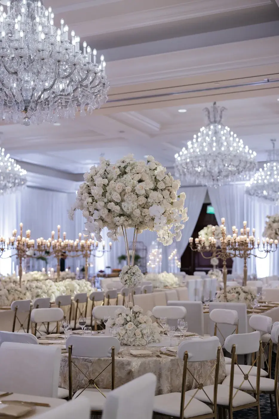 Tall white rose and orchid centerpiece under crystal chandeliers at the Four Seasons Hotel Westlake Village.
