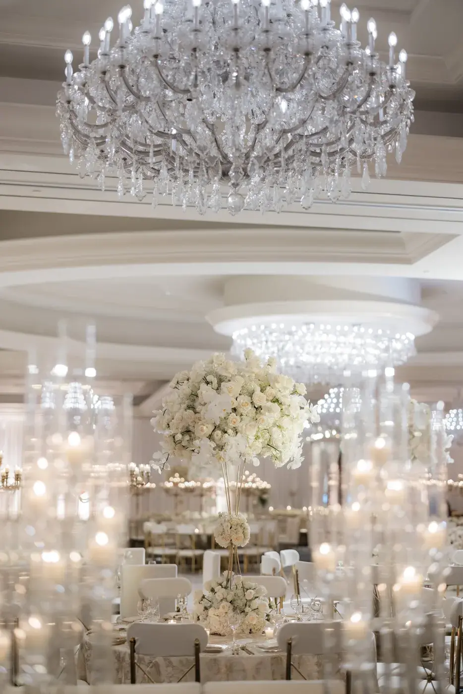 Crystal chandelier above candlelit reception tables and white floral centerpieces at the Four Seasons Hotel Westlake Village.