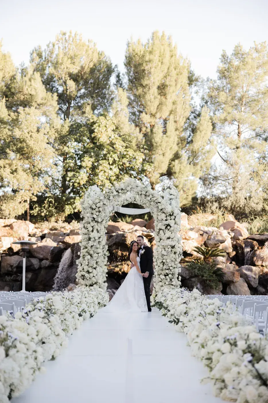 The couple beneath the floral chuppah at the Four Seasons Hotel Westlake Village.