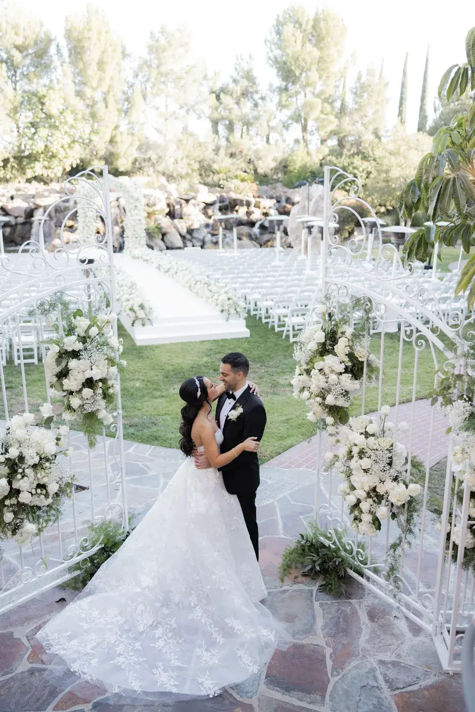 Portrait of the couple at the white garden gates at the Four Seasons Hotel Westlake Village.