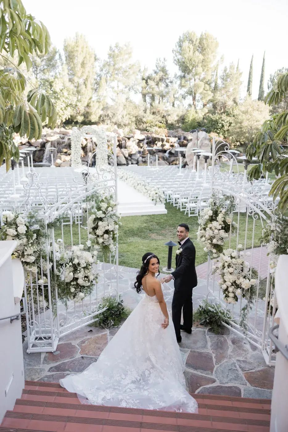 The couple at the white garden gates at the Four Seasons Hotel Westlake Village.