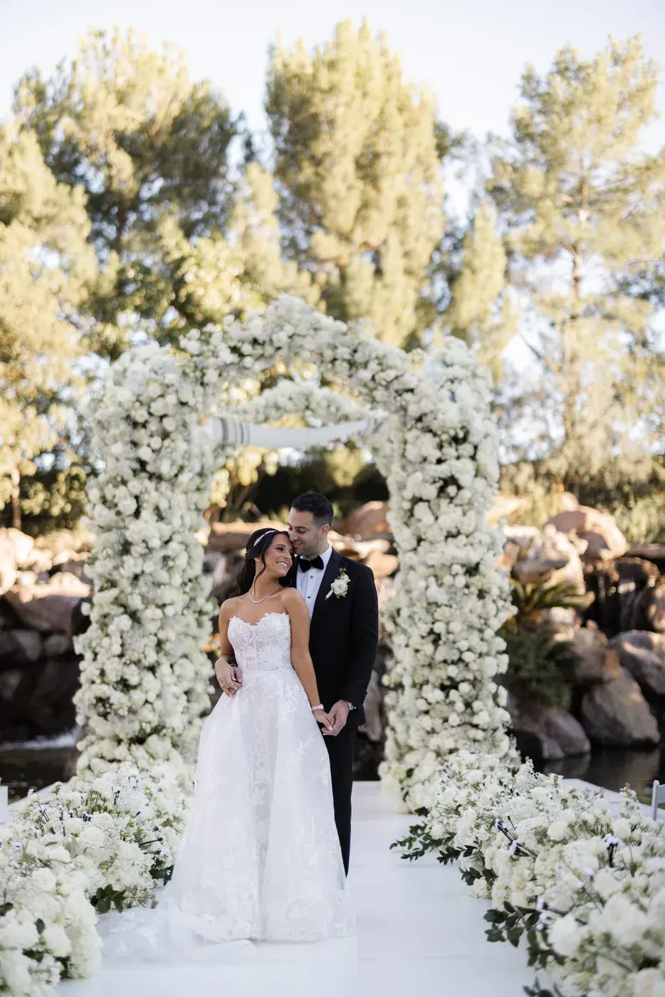 The couple under the white floral chuppah at the Four Seasons Hotel Westlake Village.