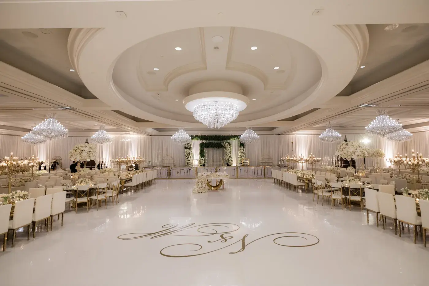 White dance floor with a gold monogram beneath the ballroom chandeliers at the Four Seasons Hotel Westlake Village.