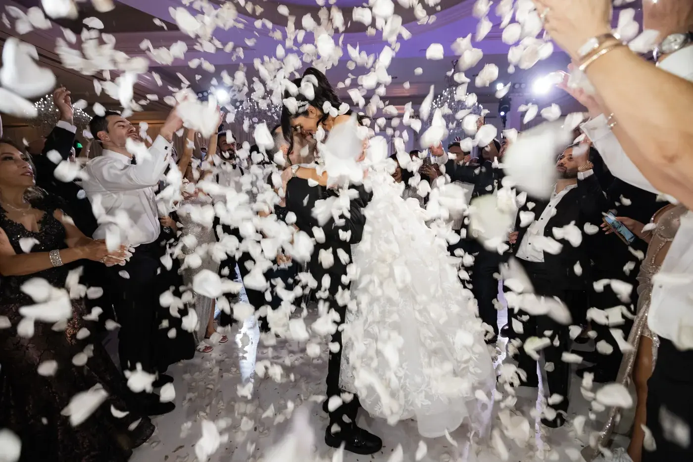 The couple surrounded by guests and falling white petals on the dance floor at the Four Seasons Hotel Westlake Village.