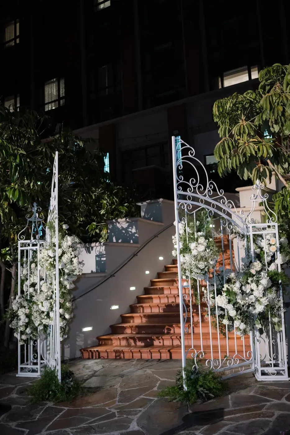 White wrought-iron garden gates and floral arrangements at the ceremony entrance at the Four Seasons Hotel Westlake Village.