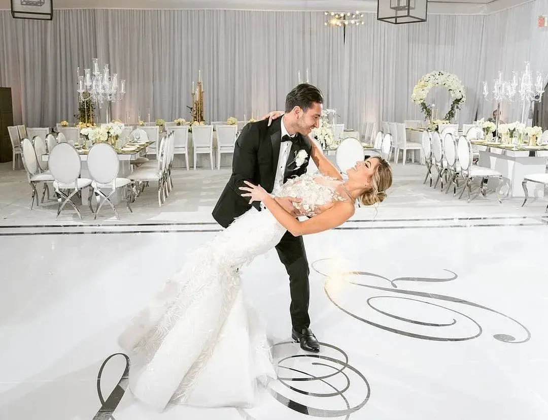 A newlywed couple sharing a private first look in a luxury white ballroom before guests arrive, at a Los Angeles wedding produced by DJ Next Level Entertainment