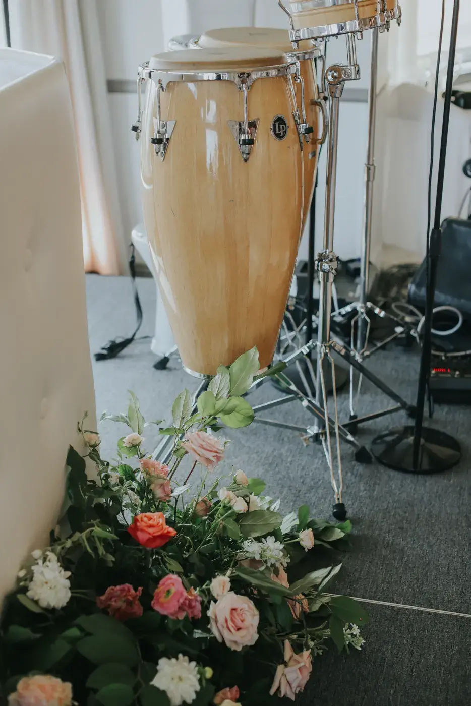 Conga drums on the stage at the Bel-Air Bay Club, with pink and white florals along the front edge.