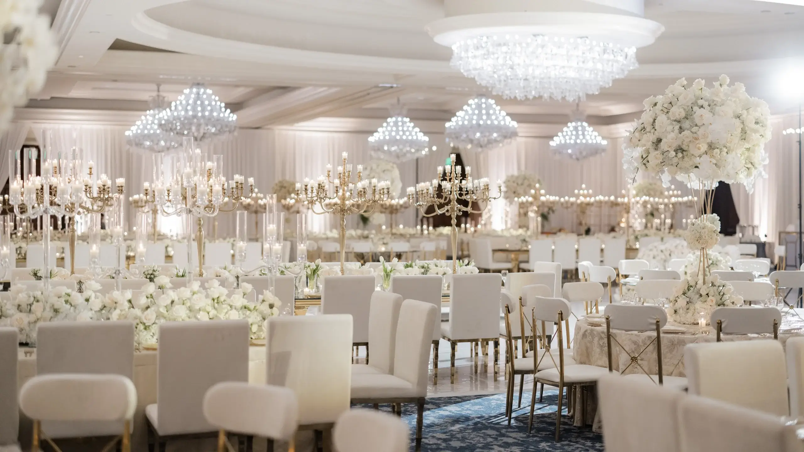 All-white wedding reception with crystal chandeliers in the Four Seasons Hotel Westlake Village ballroom