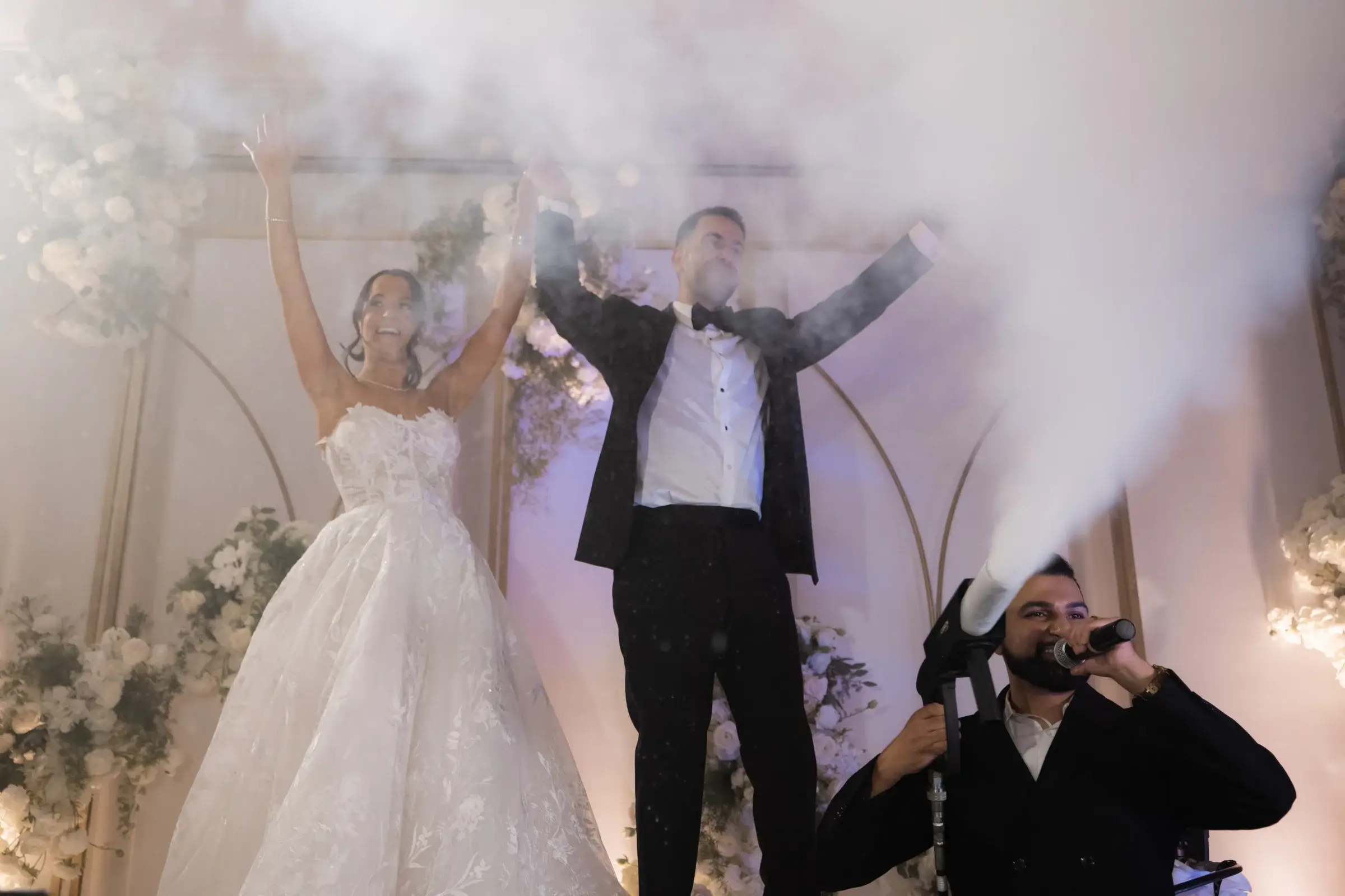 Couple celebrating on stage as CO2 jets fire during a wedding reception at the Four Seasons Hotel Westlake Village