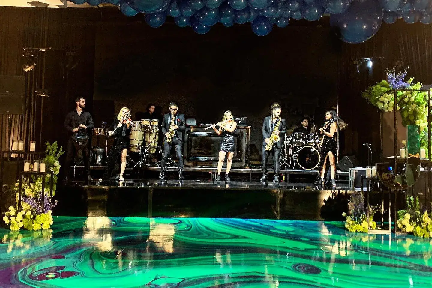 Live band performing on a lit stage with a full sound system