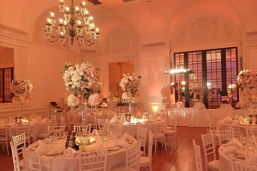 Warm amber uplighting and chandeliers in an elegant wedding reception room