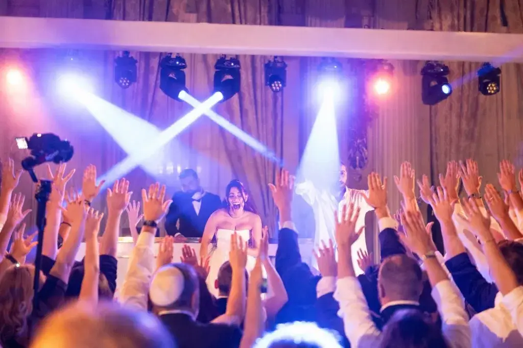 Moving-head beams and dance-floor lighting over a Los Angeles celebration